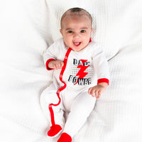 Baby girl in red & white sleepsuit.