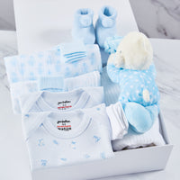 Baby boy clothing gift set, inside a white magnetic box, packed with 2 baby vests, 2 muslins, 2 pairs of socks, acrylic booties, 2 pairs of mittens, cellular blanket and blue polka dot teddy bear toy. 