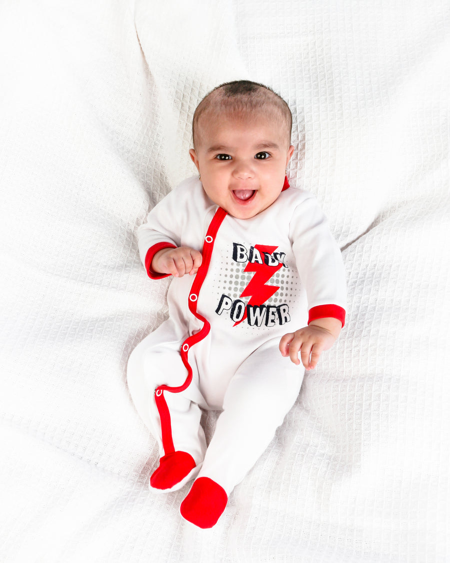 Baby girl in red & white sleepsuit. 