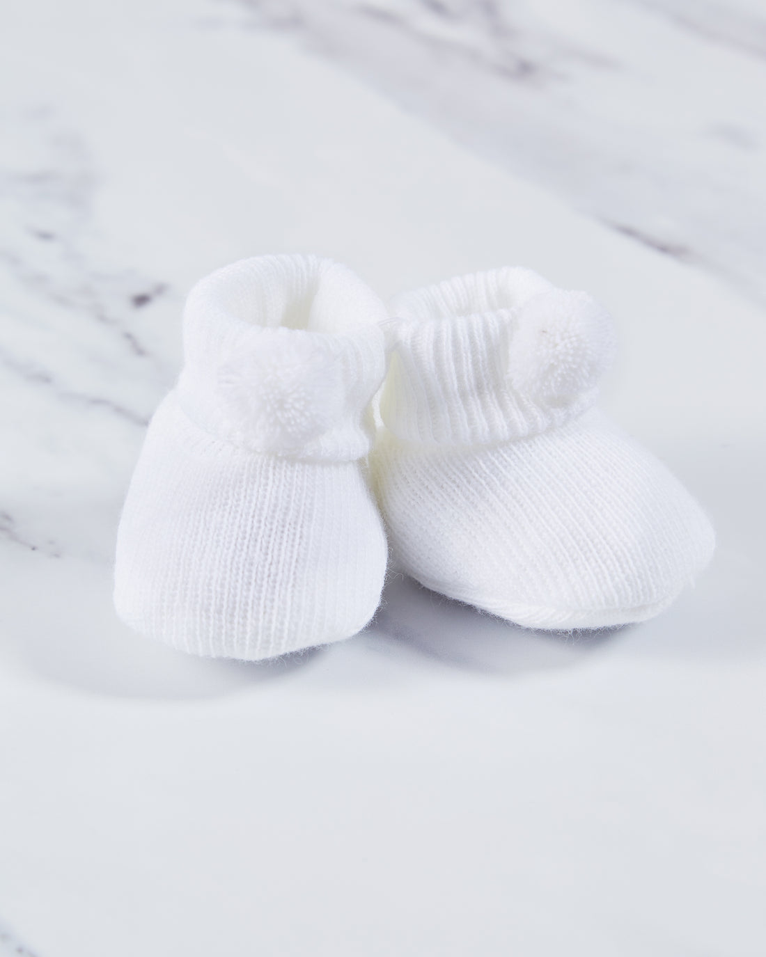 Acrylic white baby booties. 